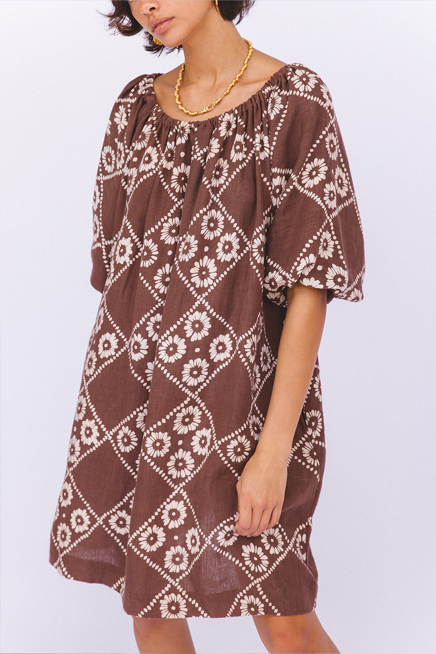 Dahlia Mini Dress Maple — upper body studio close-up, gold chain necklace, on-shoulder neckline detail, hand block print linen in maple brown white diamond daisy, boho artisan fashion | Daughters of India