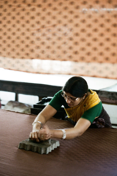 Sundress Mini Almond — artisan block printing process, Jaipur craftsperson applying hand-carved wooden block to natural cotton fabric, traditional Indian textile craft | Daughters of India