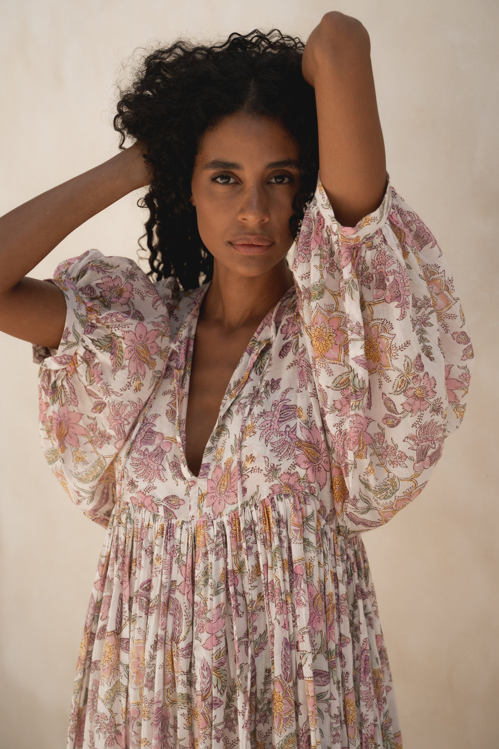 Daughters of India Kyra Maxi Dress in Fuchsia Bloom — upper body with hand in hair, V-neckline and billowed sleeves