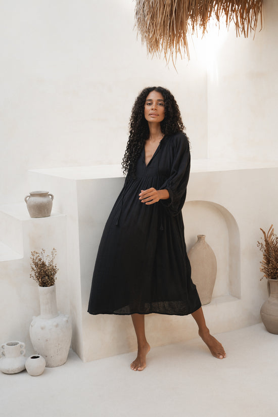 Daughters of India Kyra Midi Dress in Black Gauze — full length by white wall with ceramic pots, cotton gauze