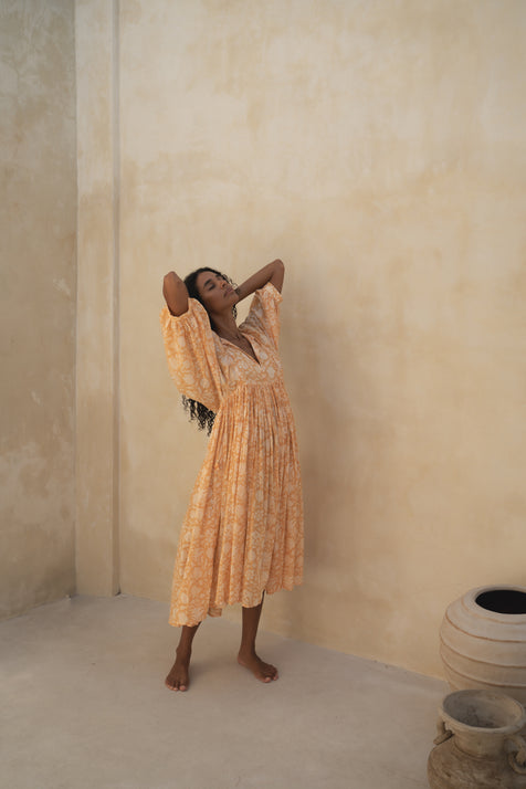 Daughters of India Kyra Midi Dress in Tangerine — standing by sand wall with clay pots, cotton